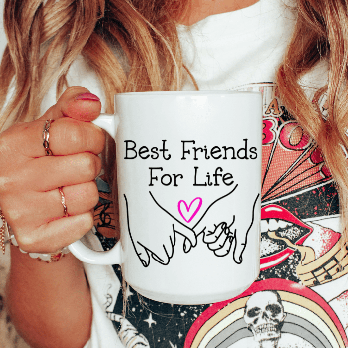 Person holding a white mug with 'Best Friends For Life' text and heart design.