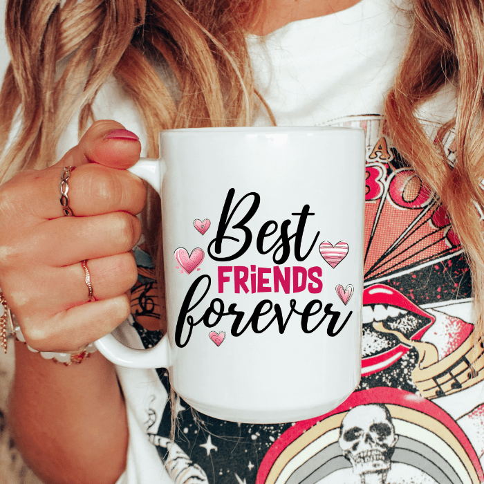 Person holding a white mug with 'Best Friends Forever' text and hearts.