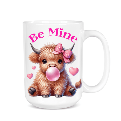 Mug with a cartoon cow blowing bubble gum, wearing a bow, and the text 'Be Mine' on a white background.