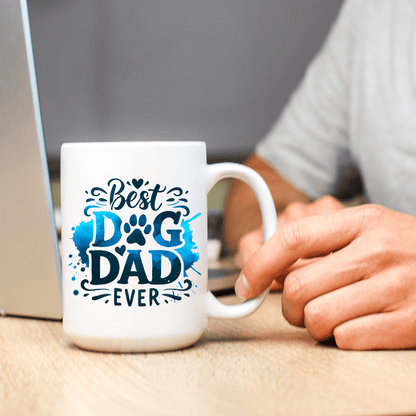 White mug with 'Best Dog Dad Ever' text held by a person at a desk.