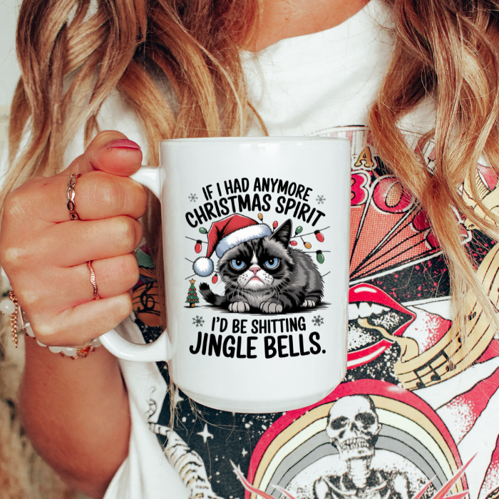 Person holding a mug with a Christmas-themed design featuring a cat and humorous text.