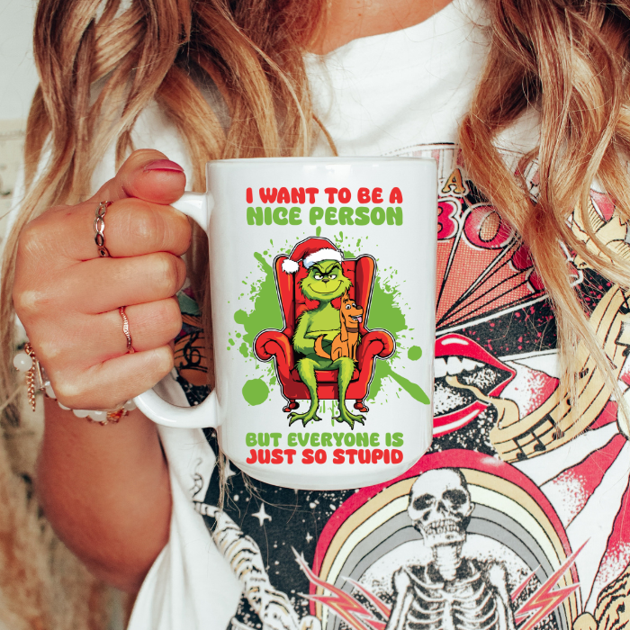 Person holding a mug with a Grinch design and text