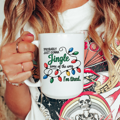 Person holding a white mug with a Christmas-themed design and text.