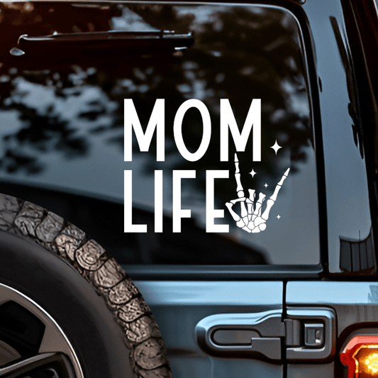 Car window with 'MOM LIFE' decal featuring a skeleton hand on a black background