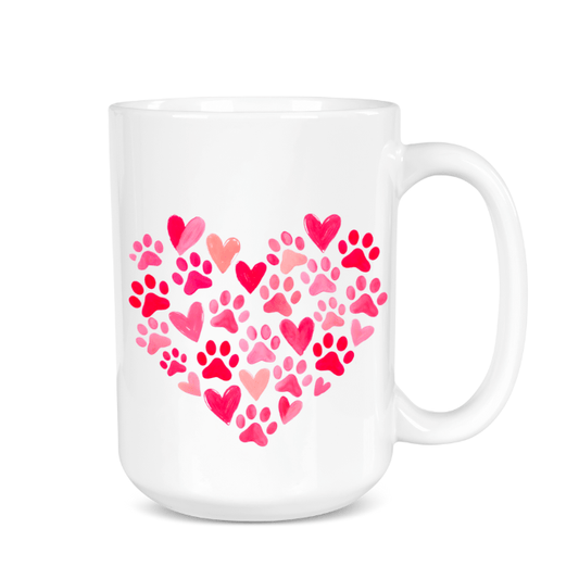 White mug with pink heart design made of paw prints on a white background