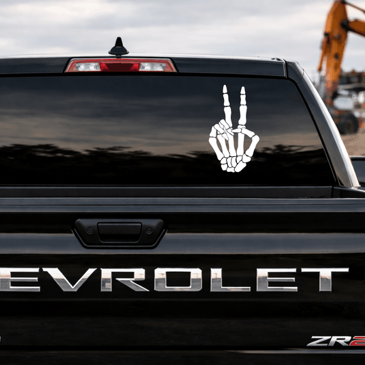 Chevrolet vehicle with a skeleton hand peace sign decal on the back window.