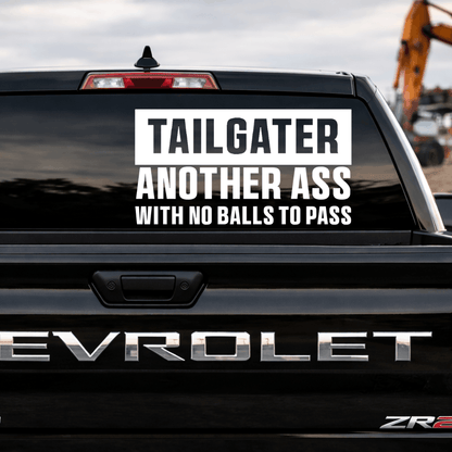 Back of a black Chevrolet truck with a humorous decal on the rear window.