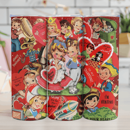 Three retro-style Valentine's Day-themed tins with vintage illustrations on a wooden surface.