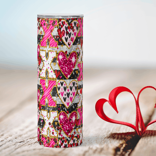 Tumbler with heart and 'XO' pattern next to a red heart-shaped object on a light background
